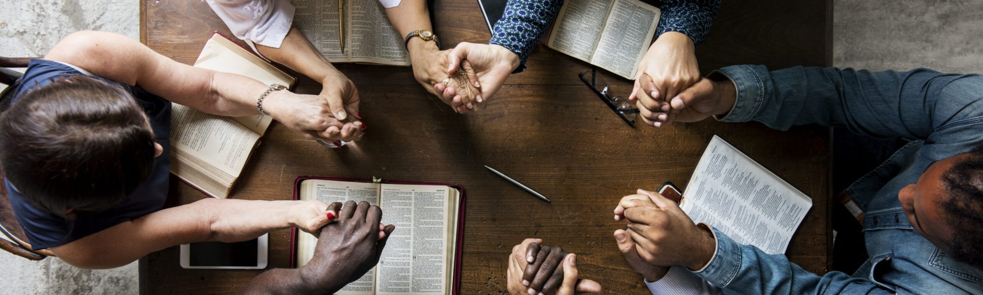 Group of people holding hands praying worship believe